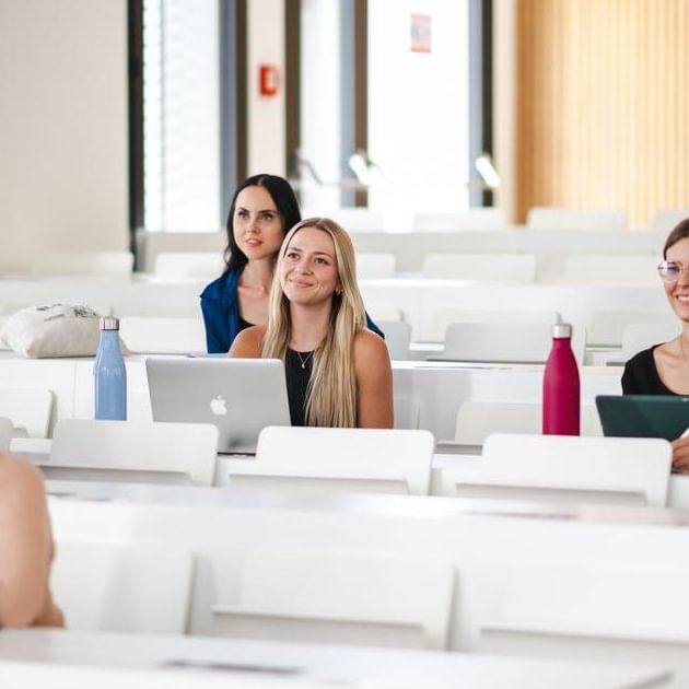 a group of women sitting in a lecture hall